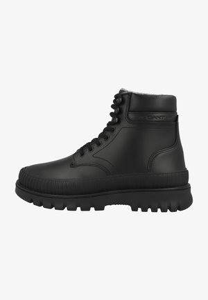 Schwarze Leder-Stiefelette mit Schnürung an der Vorderseite, gepolstertem Schaftrand, dickem Profilsohle und dezentem Markenlogo an der Seite.