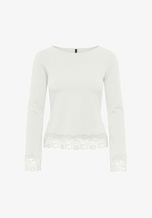 Haut blanc à manches longues avec encolure bateau, orné d'une bordure en dentelle florale aux ourlets et aux poignets.