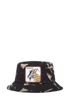 Cappello bucket tie-dye nero e crema con una toppa quadrata che presenta un design di capra e il testo "G.O.A.T" ricamato in filo marrone. Materiale in cotone.