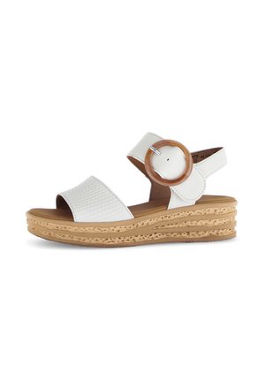 White wedge sandals with a textured strap, round wooden accent, and woven sole. The design features a closed back and an adjustable strap.
