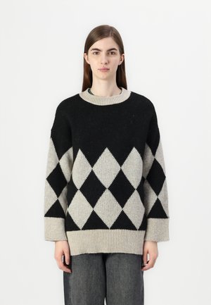 Knitted sweater featuring a black and cream diamond pattern, round neckline, dropped shoulders, and ribbed cuffs and hem.