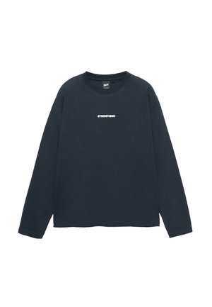 Fekete, hosszú ujjú póló, kerek nyakkivágással, a mellkason középen "STWDSTUDIO" fehér nyomott felirattal, fehér háttér előtt.