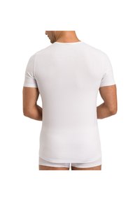 Hvid kortærmet t-shirt lavet af glat stof, med rund halsudskæring. Bagsiden har et tætsiddende design og ensartet tekstur.