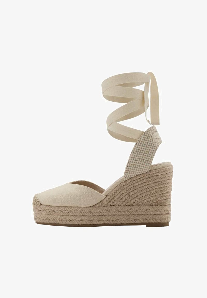 Beige Canvas-Espadrille-Wedge mit gewebter Jutesohle, Knöchelriemen mit überkreuzten Bändern, runder Zehenform und strukturiertem Rückenteil.