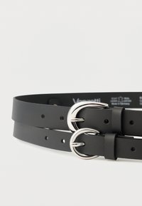 Must nahast vöö kahe hõbedase ümmarguse pandlaga, millel on mitu reguleerimisaasikut ja sile pind.