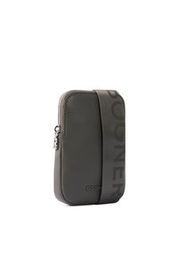 Šedá kožená crossbody taška s texturovaným povrchem, vybavená zipovým uzávěrem a širokým popruhem, na kterém se vyjímají výrazné písmena značky.