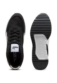 Scarpe atletiche nere con tomaia testurizzata, dettagli bianchi e suola spessa in gomma con motivo a coste e dettaglio del marchio.