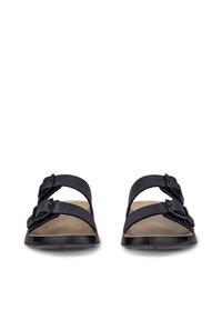 Črne sandale z odprtimi prsti, z dvema nastavljivima paščkoma z zaponkama na vsaki, oblazinjene bež podplati in ravnimi črnimi podplati, prikazane od spredaj.