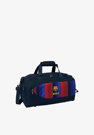 Sportowa torba w kolorze granatowym z niebieskimi i czerwonymi paskami, logo FC Barcelona, tekst "BARÇA", podwójne uchwyty i regulowany pasek na ramię.