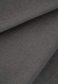 Tissu sergé diagonal gris foncé avec texture de tissage visible et plis doux.