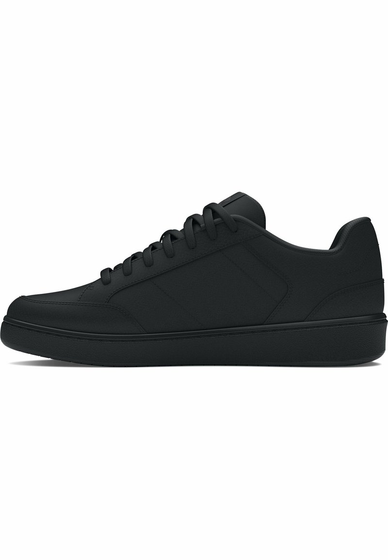 Basket noire basse avec lacets, texture lisse et semelle plate, montrée de profil sur fond blanc.