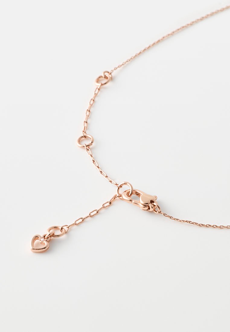Collana in oro rosa con piccoli accenti a forma di cuore e chiusura a gancio, che mette in evidenza un design delicato e una finitura raffinata.