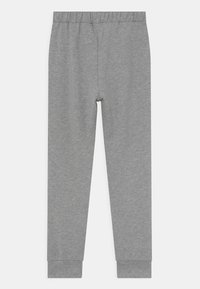 Pantalones de chándal grises con cintura elástica y puños ajustados, hechos de una tela suave y texturizada. Diseño simple y sin adornos.