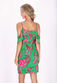 Abito verde con motivo floreale rosa, design off-shoulder, maniche arricciate e silhouette aderente. Tessuto morbido con un taglio a lunghezza ginocchio.