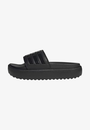Sandal em slide preta com um cabedal liso, três sulcos verticais, uma sola texturizada com um padrão estriado para melhor aderência e um design chunky.