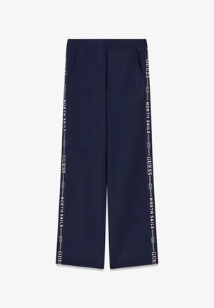 Pantalones azul marino de pierna ancha con cintura elástica y franjas laterales con texto "GUESS" y "NORTH SAILS" y gráfico de cuerda.
