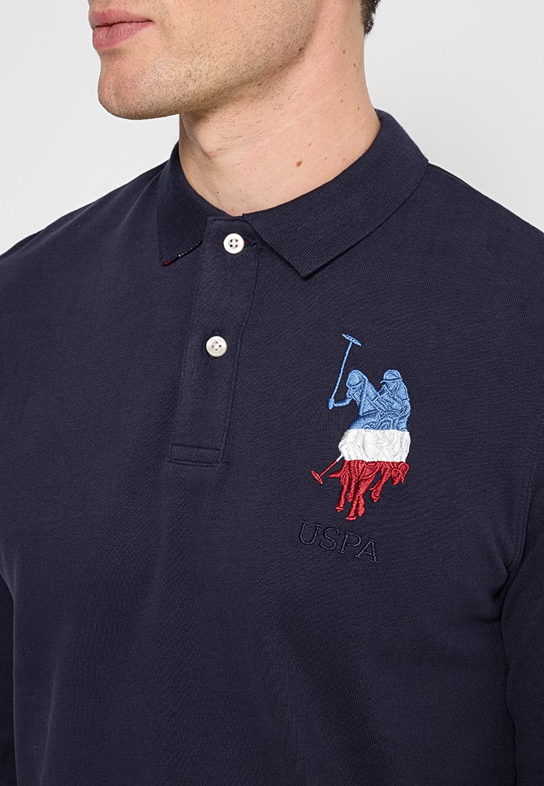Polo shirt navy in cotone, con patta a due bottoni, logo USPA ricamato con accenti blu, rossi e bianchi. Tessuto testurizzato.