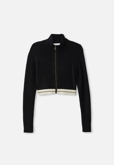 Sweater curto de malha preta com fecho e zíper, mangas longas e barra branca canelada com duas finas riscas pretas.