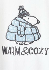 Izvezena slika koja prikazuje crtani lik u svijetloplavom preklopnom kaputu s bijelim zvjezdama, koji nosi pletenu kapu, iznad teksta "TOPLO & UGODNO."