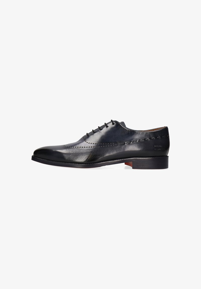 Zwart gepolijste leren Oxford-schoen met decoratieve brogue-perforaties en gestapelde hak, zijaanzicht op witte achtergrond.