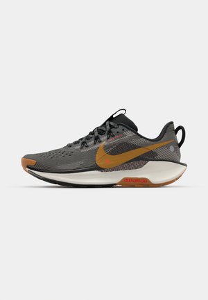 Schwarzer und grauer Sportschuh mit einem strukturierten Mesh-Obermaterial, orangefarbenem Nike-Logo und Gummisohle mit braunen Akzenten.