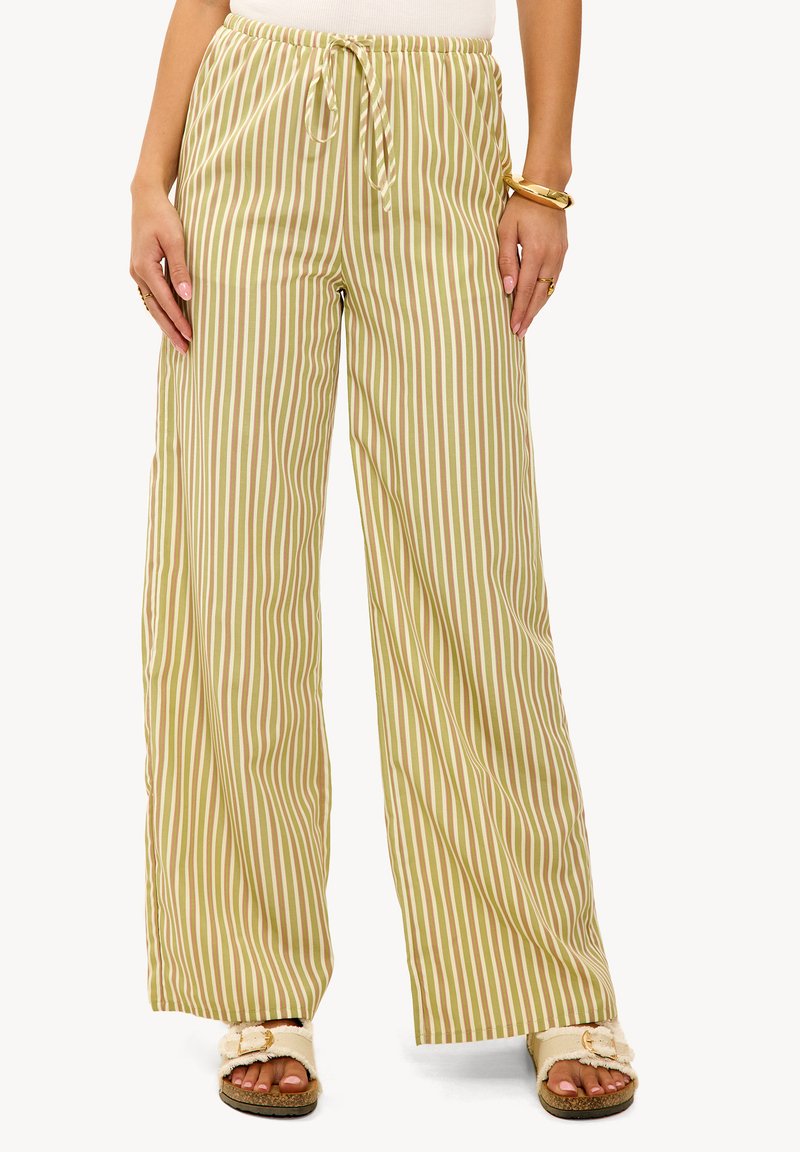 Lange broek met wijde pijpen in lichtgroen met verticale strepen. Gemaakt van een lichtgewicht stof; voorzien van een elastische tailleband en een trekkoord.