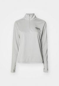 Lys grå Nike langærmet trøje med kvart lynlås, uden mønster, blød tekstur, med et lille sort logo på venstre brystområde.