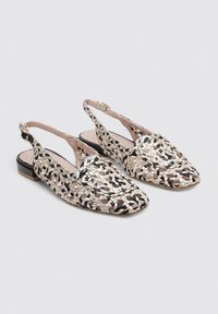 Zapatos slingback tejidos que presentan una mezcla de patrones en negro, beige y blanco; punta afilada, tacón bajo y una correa ajustable.