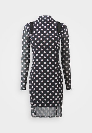 Pikendatud varrukatega must kleit, millel on valged ja punased täpid, kõrge kaelus, lõigatud õlgadega ja veidi läbipaistev tekstuur.