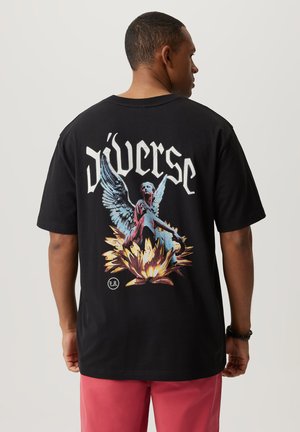 Czarna bawełniana koszulka z kolorową grafiką anioła i kwiatów na plecach, z napisem "Diverse" w pogrubionej białej czcionce.