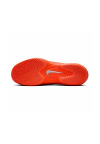 Rote Sport-Schuhsohle mit einem Zickzack-Traktionsmuster und einem silbernen Nike-Logo. Glatte Textur, abgerundete Ferse und ausladendes Design für Stabilität.