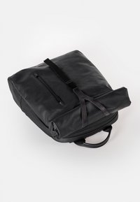 Zaino in pelle nera con tasca con zip, tracolla regolabile e design arrotolato. Texture liscia e forma strutturata.