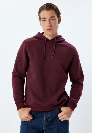 Burgundy hoodie with a kangaroo pocket, drawstring hood, and ribbed cuffs. Made of soft fabric, features a relaxed fit and minimal design.
