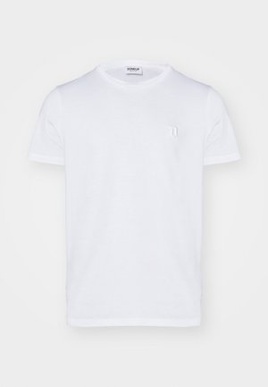 T-shirt blanc à manches courtes avec un petit logo, associé à un pantalon cargo noir avec des poches latérales et des chaussures noires à la finition brillante.