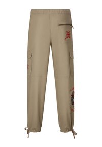 Beige cargobyxor med elastisk midja, broderad grafik, två sidofickor och dragsko vid ärmsluten. Har en ficka med dragkedja.