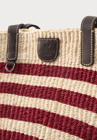 Υφαντή μπεζ και κόκκινη ριγωτή τσάντα ώμου με λαβές από σκούρο καφέ δέρμα και δερμάτινο ταμπελάκι "Weekend MaxMara" κοντά στο πάνω κέντρο.