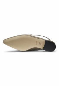 Beige pointed-toe shoe with a low heel, featuring a smooth leather exterior, slim strap, and a textured rubber sole. Brand logo visible.