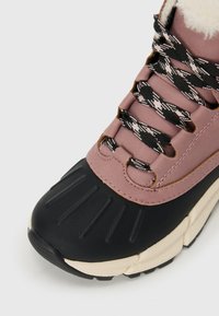 Scarpa da atletica rosa e nera con punta in gomma testurizzata, tomaia in pelle sintetica, lacci a fantasia e rivestimento interno soffice.