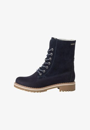 Bottes lacées en suède bleu marine avec une finition texturée, semelle en caoutchouc et quincaillerie en argent. Présente un col rembourré et des lacets blancs contrastants.
