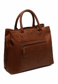 Bruin leren totebag met dubbele handvatten, een ritsvak aan de voorkant en subtiele branding aan de voorkant. Glad oppervlak en gestructureerd ontwerp.