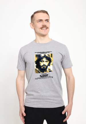 Šedé bavlněné tričko s grafickým potiskem mužské tváře s tmavými vlasy, žlutými akcenty a textem odkazujícím na "Al Pacino Serpico."