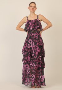 Blomster maxi kjole i sort og pink, med lagdelte flæser, spaghetti-stropper og et bælte i taljen for definition. Gennemsigtigt stof med en svævende silhuet.