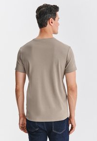 Szara bawełniana koszulka z krótkim rękawem i okrągłym dekoltem, charakteryzująca się gładką teksturą i dopasowanym fasonem, zaprezentowana od tyłu.