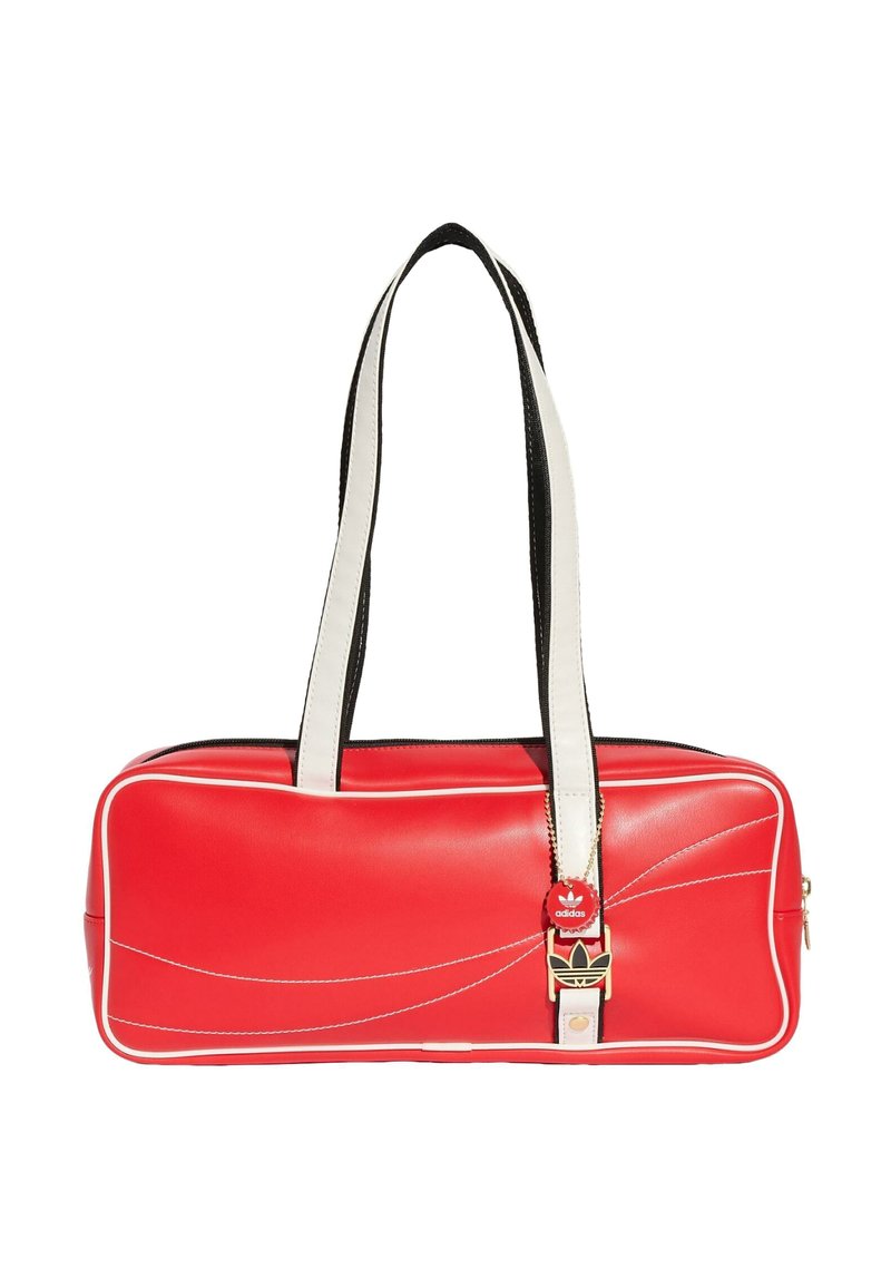 Red rectangular Adidas shoulder bag with white piping and long white handles, featuring black and gold logo detail on front.