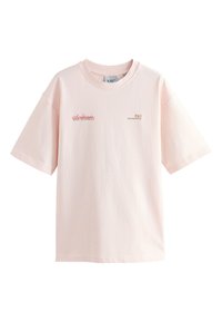 T-shirt en coton rose clair à coupe décontractée, col rond et manches courtes. Présente un texte imprimé rouge sur le devant et une texture subtile.