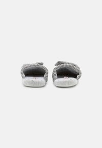 Gray fabric slippers with a braided texture, open back, and soft inner lining. Features a cushioned sole and decorative knot detail on top.