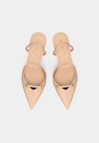 Sandales nude à bout pointu avec fines lanières et un petit détail découpé. Conçues en matériau texturé avec des accents en métal doré.