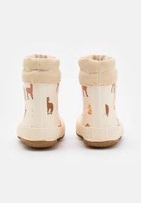 Barnstövlar i creme med djurmönster, texturerad tygkrage, räfflad gummisula och vadderad topp för komfort och stöd.