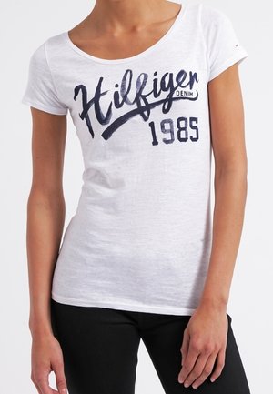 Wit katoenen T-shirt met een marineblauwe grafische print met "Hilfiger Denim" en "1985." Ronde halslijn en korte mouwen.