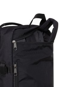 Schwarzer Rucksack mit teilweise geöffnetem oberen Reißverschluss, der das gepolsterte Laptopfach sowie zwei Reißverschlüsse an Vorder- und Obertaschen zeigt.
